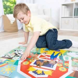 A young boy in a yellow shirt and jeans assembles the Melissa & Doug Ms. Rachel Floor Puzzle Farm Ms Rachel while kneeling on a round rug in a bright, tidy room.