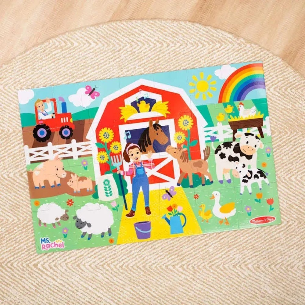 0000772504164-6 The Melissa & Doug Ms. Rachel Floor Puzzle Farm Ms Rachel features a colorful farm scene with a farmer, various animals, a red barn, tractor, rainbow, and a bright sunny sky on a sturdy wooden surface.