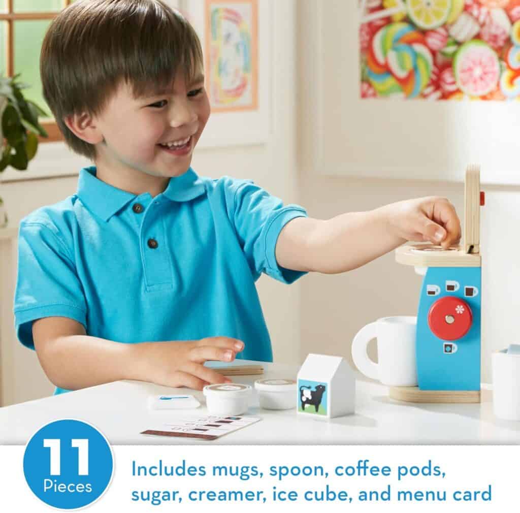 A young boy is playing with the Melissa & Doug Brew and Serve Wooden Coffee Maker Set.