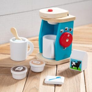 A Melissa & Doug Brew and Serve Wooden Coffee Maker Set with cups and mugs on a wooden table.