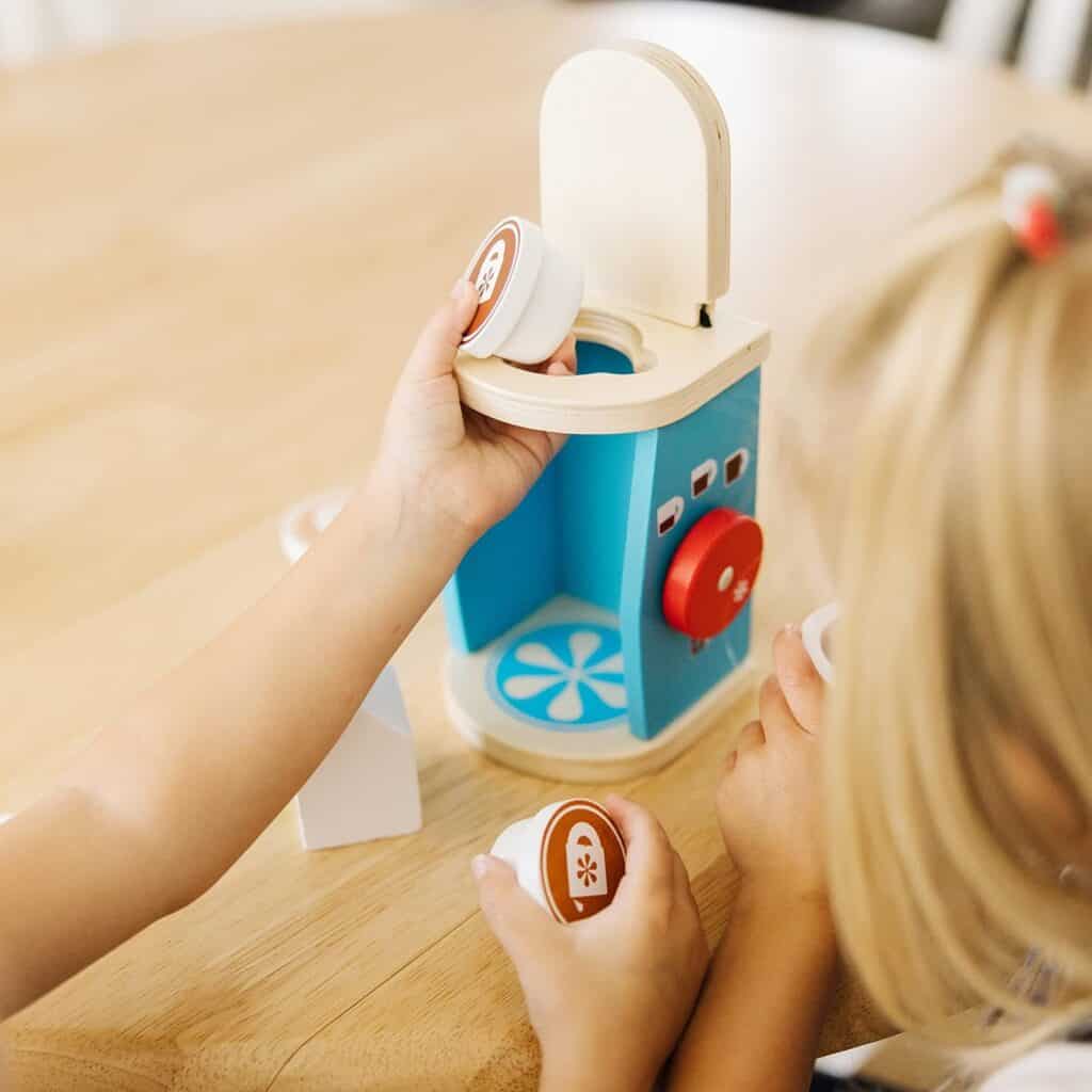 Two children playing with the Melissa & Doug Brew and Serve Wooden Coffee Maker Set.