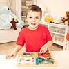 A young boy playing with a Melissa & Doug Locks and Latches Board.