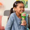 A little girl is smiling while holding the First Act CoComelon Musical Sing-Along Microphone Plays Clips ‘Thank You’ Song Clip.