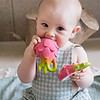 A baby is chewing on an Oli & Carol Fucsia de Dragonfruit Baby Teether Natural Rubber.