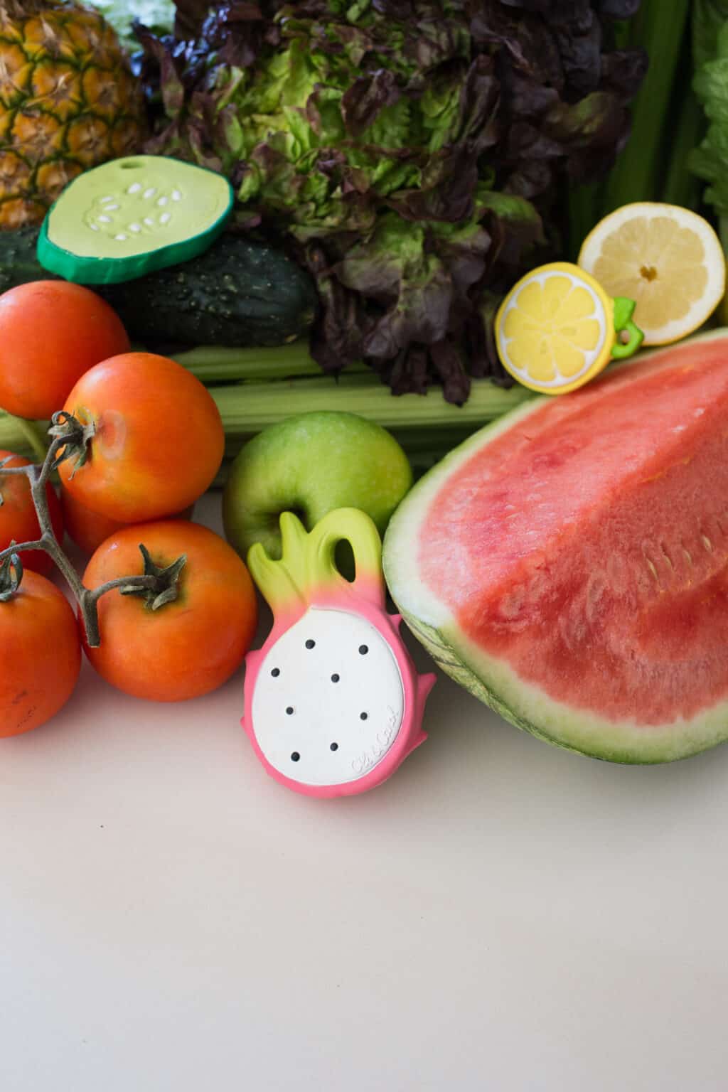 A Oli & Carol Fucsia de Dragonfruit Baby Teether Natural Rubber on a table.