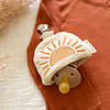 An Itzy Ritzy Soothe & Store Pacifier Clip & Storage Pouch with a sun on it.