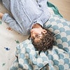 A young boy laying on a bed with a toy on it.