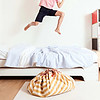 A young boy jumping on top of a bed.