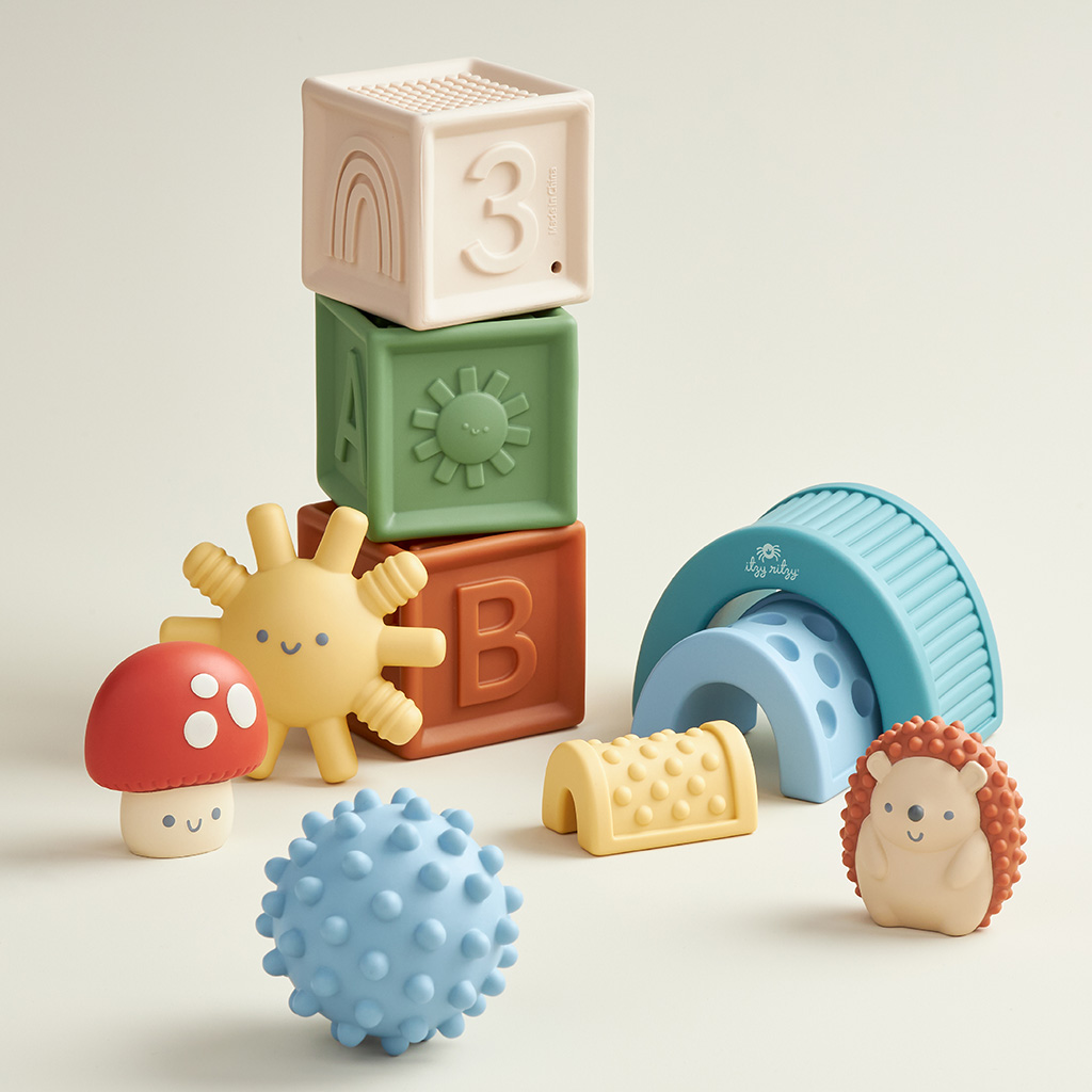 BL853201_Itzy_Ritzy_Toy_Itzy_Blocks_DigitalShelf A collection of Itzy Ritzy Sensory Blocks 10-Piece Set including stackable blocks, a textured ball, and whimsical animal-shaped toys on a light background.