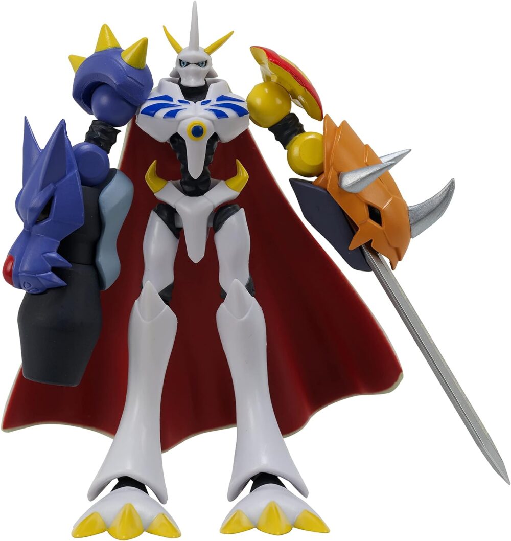 A humanoid robot toy with white, blue, and yellow armor stands holding a sword and shield. It has a red cape and a large blue and orange horned gauntlet on its left arm.