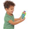 cocomelon-presslearnremote-37 A smiling young boy in a green shirt holds the CoComelon Press and Learn Remote Toddler Learning Toy, featuring colorful buttons and a cheerful cartoon face.
