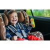 cocomelon-singingremote-70 A young child in a car seat smiles and holds the CoComelon Learn and Play Singing Remote Toddler Musical Toy Microphone, which lights up and plays nursery songs, inside a vehicle.