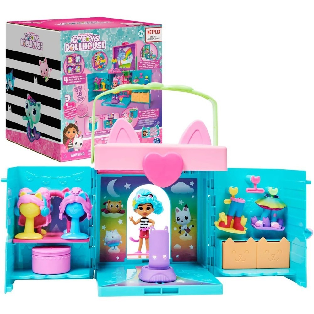 gabbydollhouse-dressupcloset-57 Gabby’s Dollhouse Dress-Up Closet Portable Playset features a cat-ear design, comes with a Gabby doll, surprise toys, dress-up accessories, and a colorful photo shoot backdrop; product packaging for this Netflix-inspired set is shown in the background.