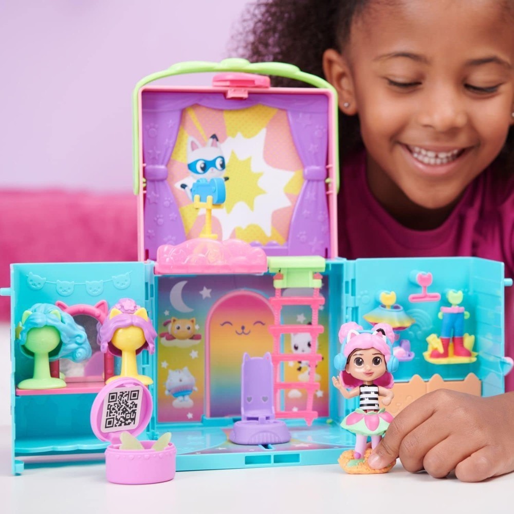 gabbydollhouse-dressupcloset-63 Smiling child playing with the Gabby’s Dollhouse Dress-Up Closet Portable Playset, featuring a Gabby doll, surprise accessories, wigs, and fun animal-themed decorations—just like in the Netflix show!.