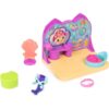 gabbydollhouse-mercatsparoom-81 Gabby’s Dollhouse MerCat’s Spa Room Playset features a colorful vanity, shell-shaped chair, animal figurine, green container, shell tub, and pink bracelet on a yellow base with a decorative backdrop.