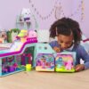gabbydollhouse-mercatsparoom-85 A young girl plays with the Gabby’s Dollhouse MerCat’s Spa Room Playset, which features a MerCat figure, surprise dollhouse furniture, and fun accessories on a table in a decorated room.
