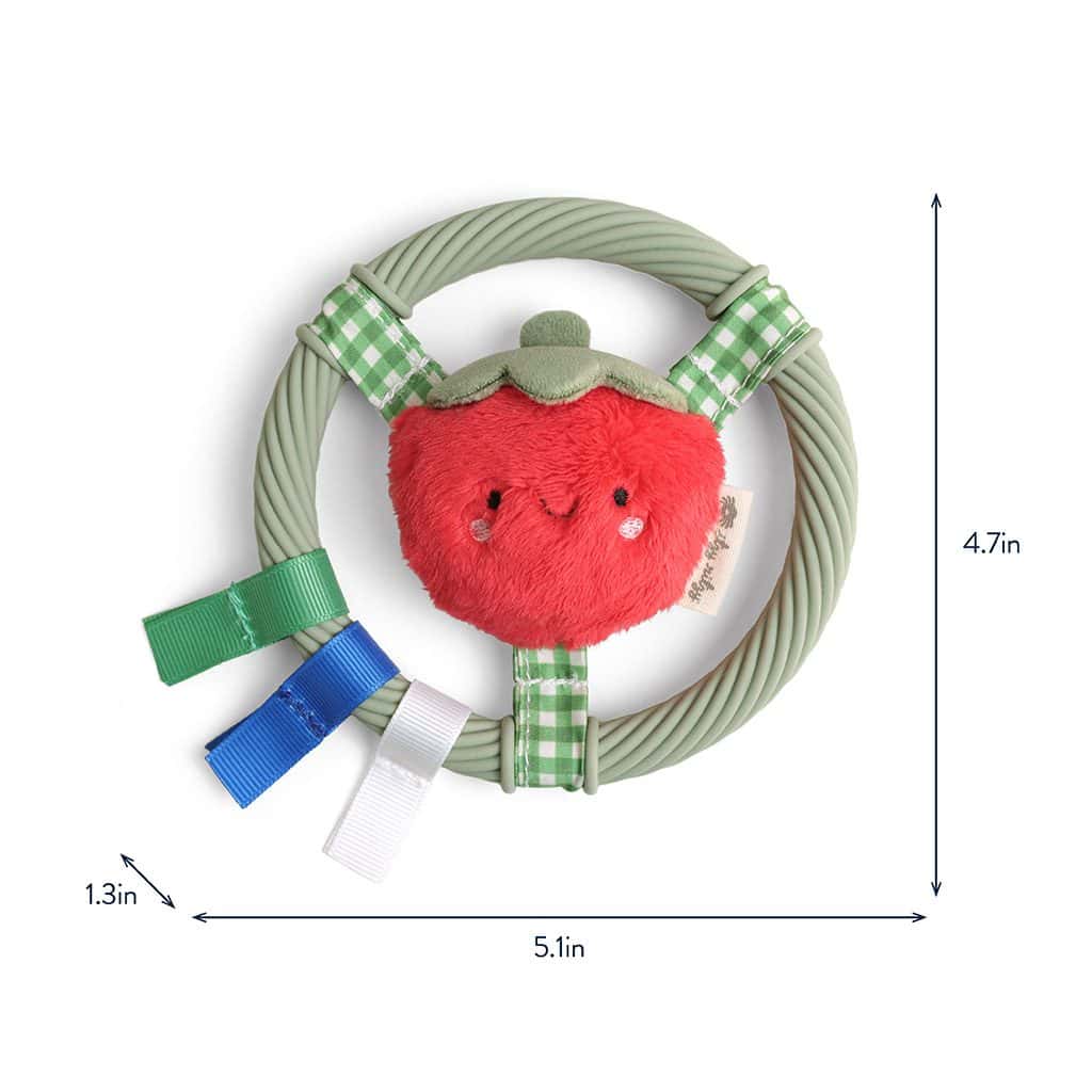 itzy-ring-pal-tomato-04 Circular toy with a plush red strawberry character attached and green, blue, and white ribbon tabs; dimensions are 4.7in high, 5.1in wide, and 1.3in deep.