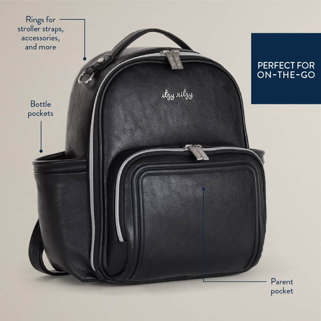 itzy-ritzy-101401619-itzy-mini-plus-backpack-noir-8 Black backpack with compartments labeled for bottle pockets, stroller strap rings, and a parent pocket. Text reads "PERFECT FOR ON-THE-GO.