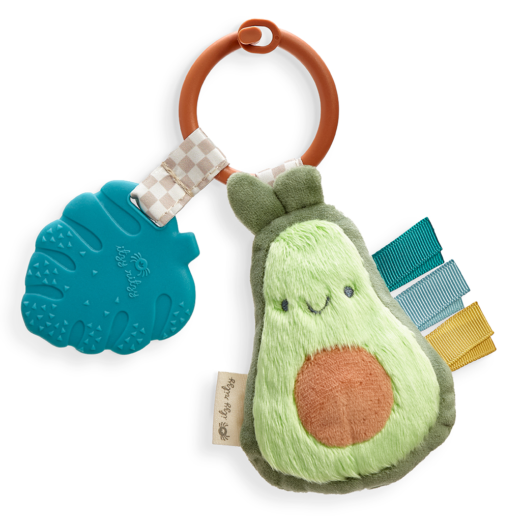 231220_Itzy_Ritzy_Digital_Shelf_ItzyPalAvocado A plush Itzy Ritzy - Itzy Pal toy with a textured blue leaf teether and colorful ribbon tags, attached to a ring.