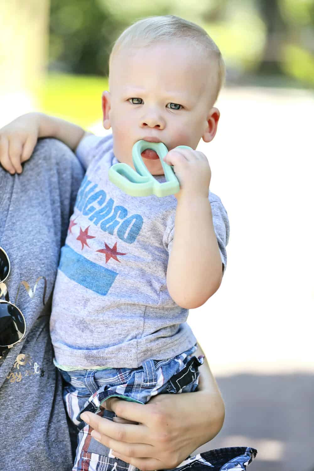 A woman holding a baby holding a toothbrush.