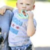 A woman holding a baby holding a toothbrush.