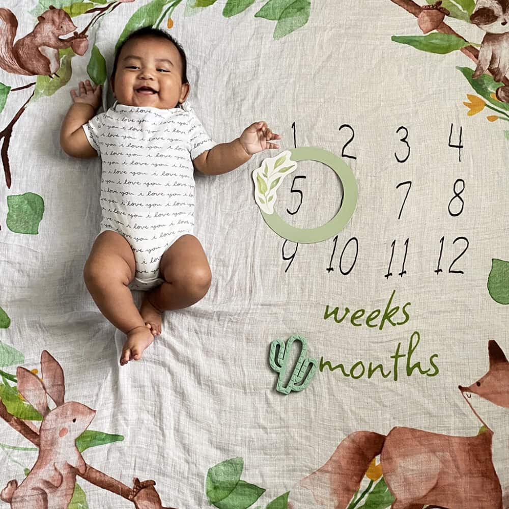A baby is laying on a blanket with a number on it.