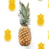 A pineapple is surrounded by a group of yellow pineapples.