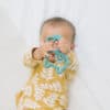 A baby is playing with a toy on a bed.