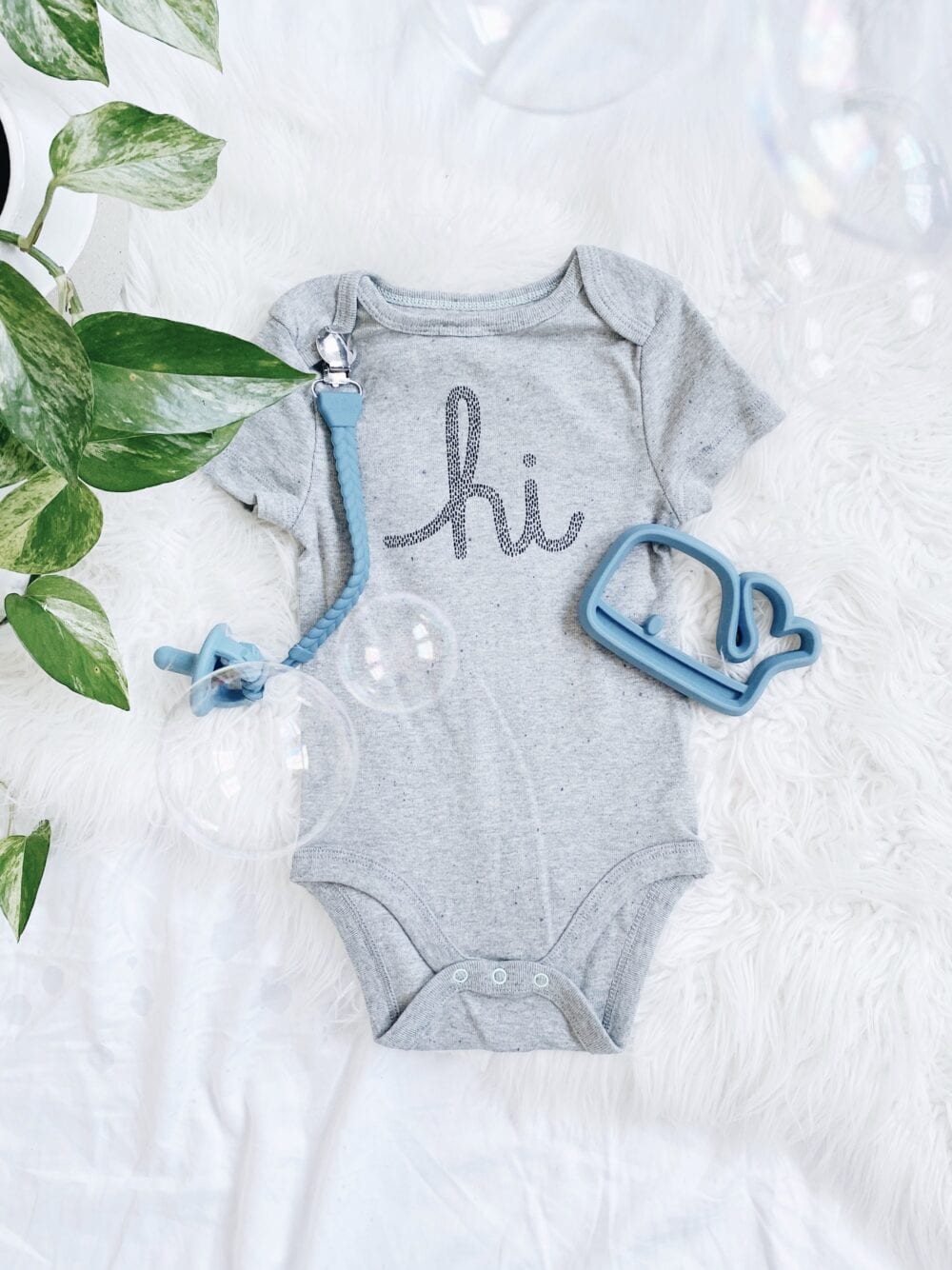 A baby's bodysuit with the word hi on it.