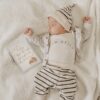 A baby laying on a blanket with a book on it.