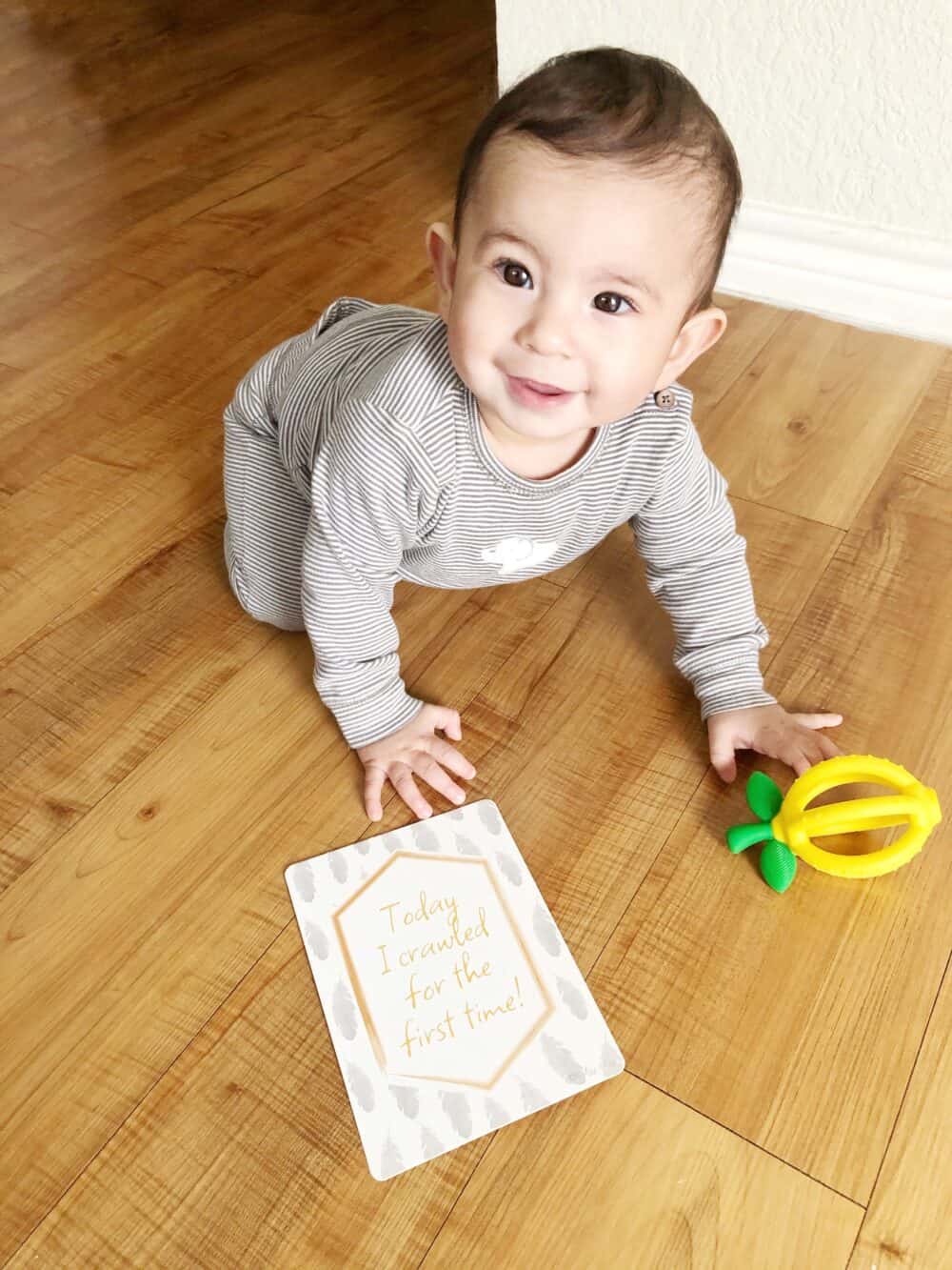 A baby is playing with a toy on the floor.