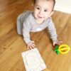 A baby is playing with a toy on the floor.