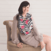 A woman sitting on a chair wearing a Mom Boss™ 4-IN-1 Multi-Use Nursing Cover & Scarf.