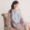 A woman sitting on a chair wearing a Mom Boss™ 4-IN-1 Multi-Use Nursing Cover & Scarf.