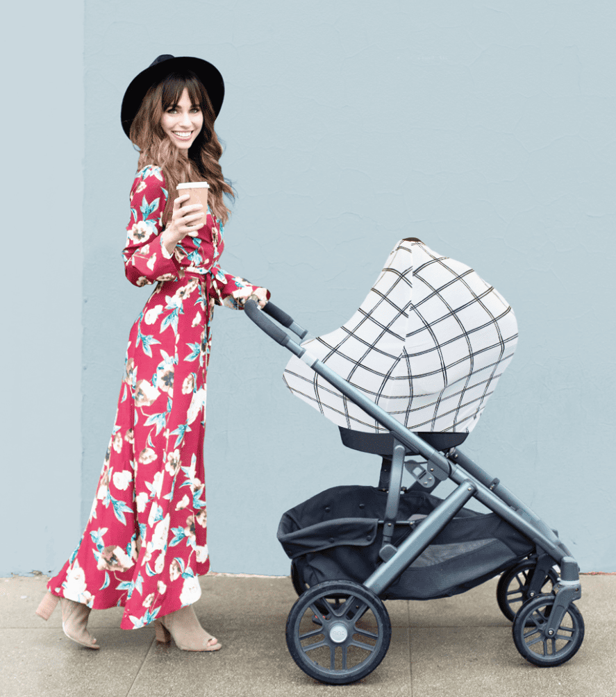 A woman in a floral dress pushing a Mom Boss™ 4-IN-1 Multi-Use Nursing Cover & Scarf stroller.