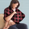 A woman holding a baby in a Mom Boss™ 4-IN-1 Multi-Use Nursing Cover & Scarf.
