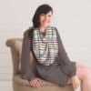 A woman sitting on a chair wearing a Mom Boss™ 4-IN-1 Multi-Use Nursing Cover & Scarf.