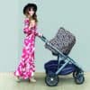 A woman pushing a stroller with a Mom Boss™ 4-IN-1 Multi-Use Nursing Cover & Scarf.