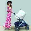 A woman in a floral dress pushing a Mom Boss™ 4-IN-1 Multi-Use Nursing Cover & Scarf stroller.