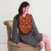 A woman sitting on a chair wearing a Mom Boss™ 4-IN-1 Multi-Use Nursing Cover & Scarf.