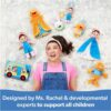 A woman in pink and denim overalls lies on the floor, surrounded by plush toys and the Ms Rachel Official Sensory Take-Along Toy Herbie Doll Baby Teether Rattle Stroller Clip (for 3 months+). A blue banner below reads: “Designed by Ms. Rachel & developmental experts to support all children.”.