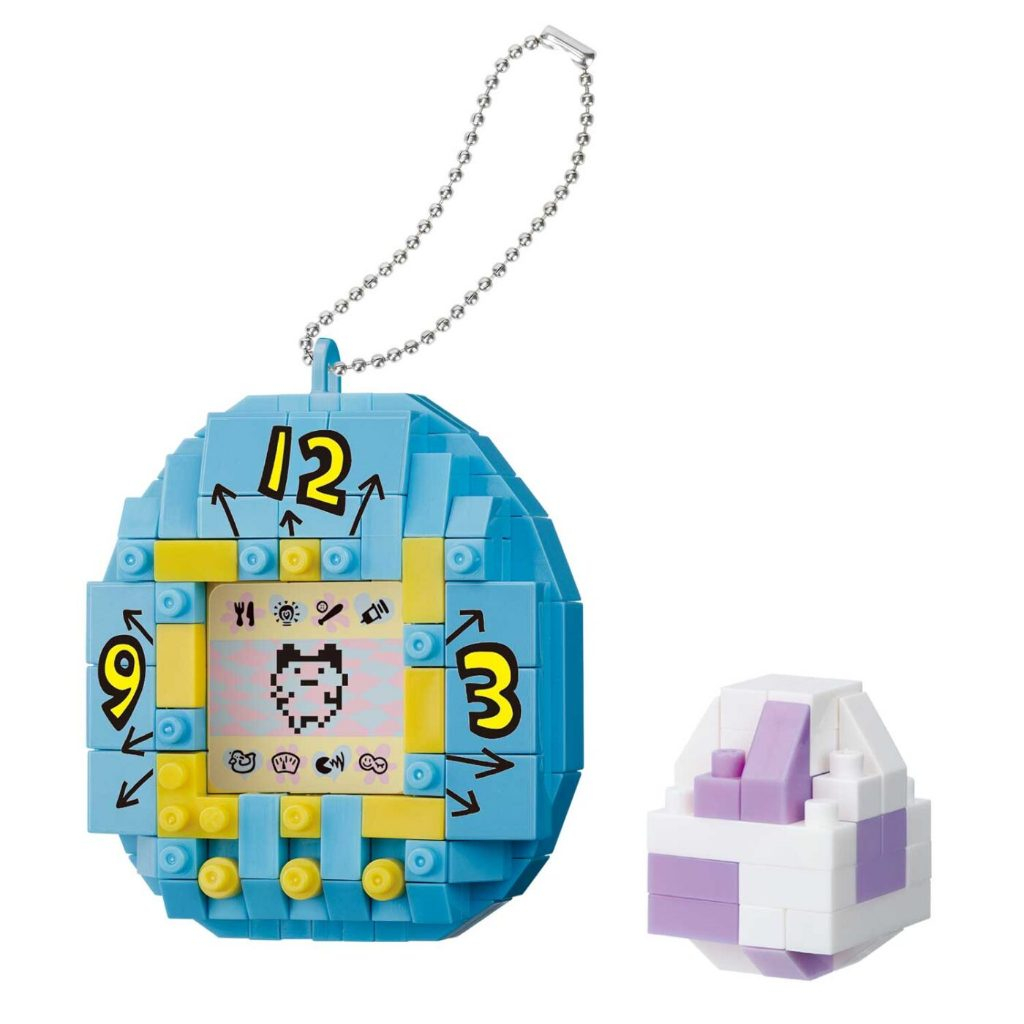 nanoblock-tamagotchi-141 Kawada nanoblock Tamagotchi mininano Blind Box First Generation Tamagotchi Mini Block Kit featuring a toy egg-shaped keychain with a yellow-bordered screen displaying pixel art, accompanied by a small purple and white accessory.