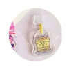 tamagotchi-uni-dustplug-1 A clear acrylic keychain charm titled “Tamagotchi Uni Keychain Dust Plug,” featuring an illustrated slice of cake with cat ears and face, is attached to a yellow loop and designed as mobile phone Type C Tama merchandise, shown against a white background.